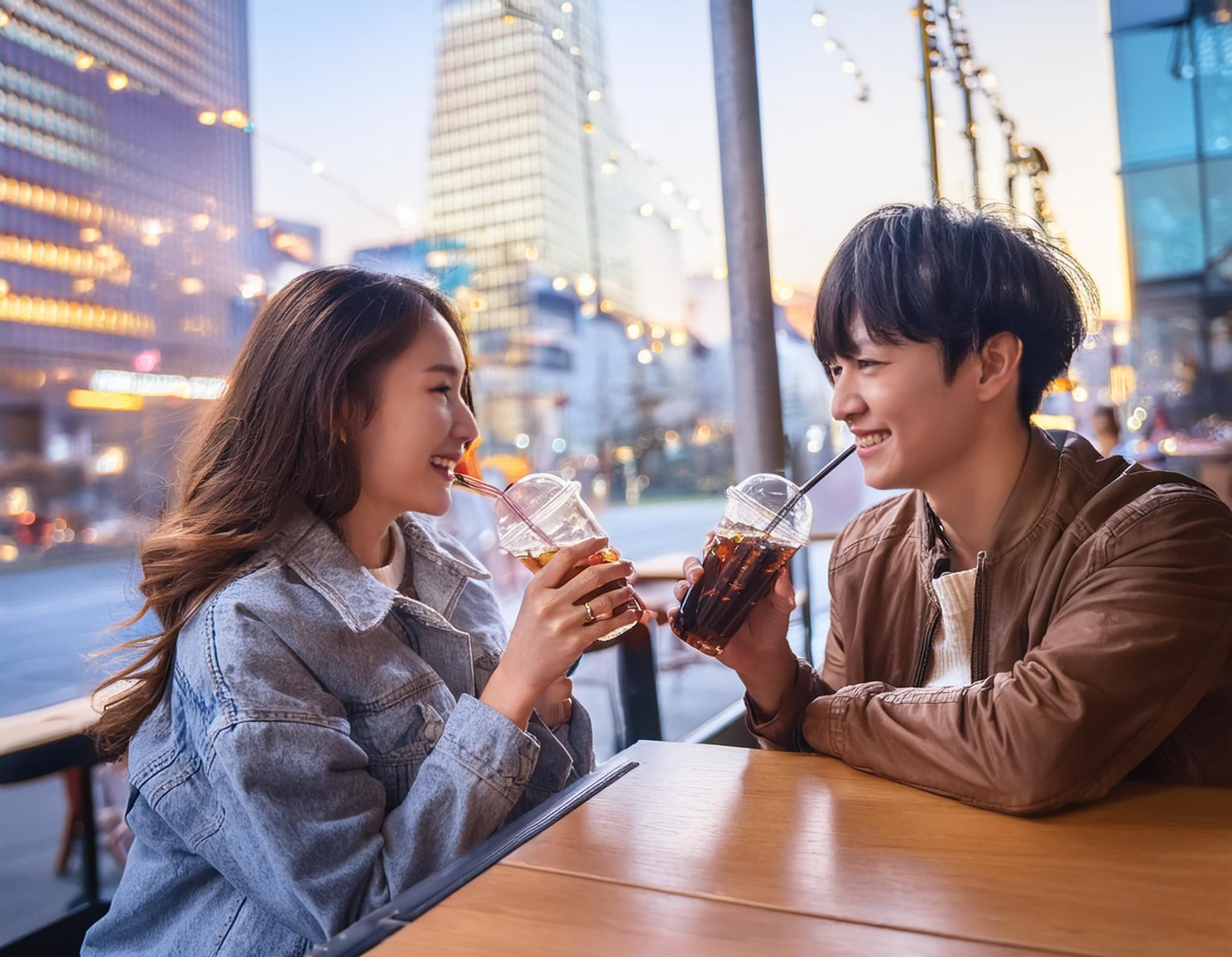 都心のおしゃれなカフェでクラフトコーラを飲む若いカップル